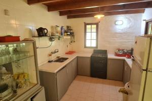 a kitchen with a sink and a refrigerator at Casaquinta en la costa del Rio in General Roca