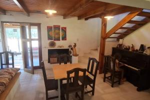 a living room with a table and a piano at Casaquinta en la costa del Rio in General Roca