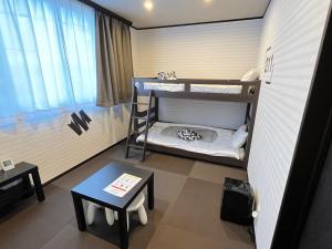 a small room with two bunk beds and a table at SAMURISE 81INN - Vacation STAY 60974v in Azagawa