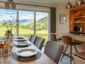 comedor con mesa y sillas y ventana grande en Mountain Chalet An der Mur, en Sankt Lorenzen ob Murau