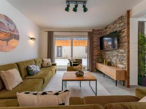 a living room with a couch and a tv at Mountain Chalet An der Mur in Sankt Lorenzen ob Murau