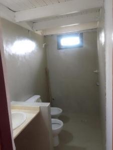 La salle de bains est pourvue de 2 toilettes, de 2 lavabos et d'une fenêtre. dans l'établissement La Pasiva, à Villa Giardino