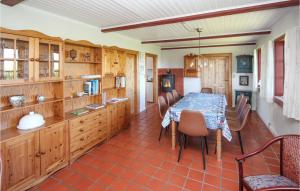ein Esszimmer mit einem Tisch und einigen Holzschränken in der Unterkunft 4 Bedroom Stunning Home In Sams in Brundby