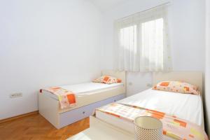 a bedroom with two beds and a window at Apartments with a parking space Dugi Rat, Omis - 11443 in Dugi Rat