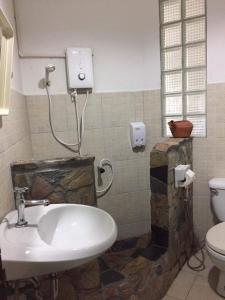 uma casa de banho com um lavatório e um WC em Jung Ja Hut em Sai Yok