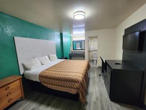 um quarto de hotel com uma cama e uma televisão de ecrã plano em Green Garden Inn em Greensboro