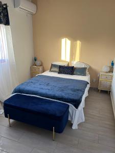 a bedroom with a large bed with a blue blanket at Villa Belle Ile en Mer in Capesterre-de-Marie-Galante