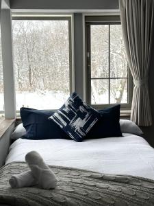 ein Bett in einem Schlafzimmer mit einem Fenster mit Schnee im Freien in der Unterkunft Legend Inn Myoko in Myōkō