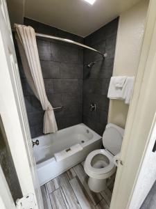 a bathroom with a toilet and a bath tub at Green Garden Inn in Greensboro