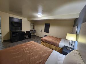 a hotel room with two beds and a desk at Green Garden Inn in Greensboro