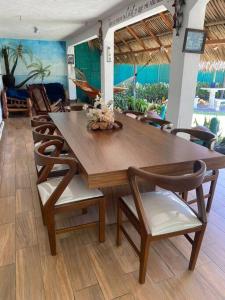 una mesa de madera y sillas en una habitación en Casa en el puerto frente al mar!, en Puerto San José