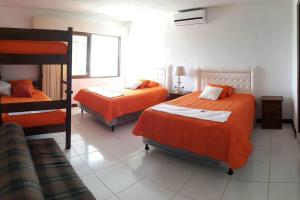 una camera con 2 letti e lenzuola arancioni di Casa en el puerto frente al mar! a Puerto San José