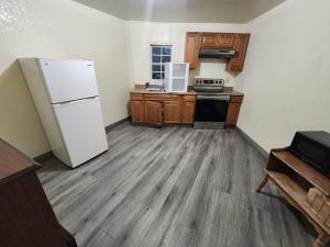 a kitchen with a white refrigerator and wooden cabinets at Green Garden Inn in Greensboro
