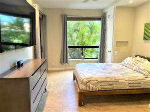 1 dormitorio con cama y ventana grande en Coconut at Shores - Waikoloa Beach Resort, en Waikoloa
