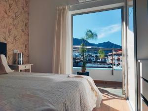 a bedroom with a large window with a view of a marina at Apartamento Starlight La Aldea I in San Nicolás