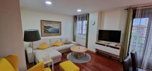 sala de estar con sofá y TV en El Rincón de Carbayedo - Avilés - 4 hab, en Avilés
