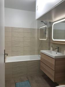 La salle de bains est pourvue d'une baignoire et d'un lavabo. dans l'établissement Sevigné Plage, à Deauville