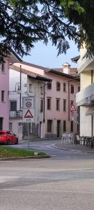 un letrero de la calle frente a un edificio rosa en casettafagagna, en Fagagna