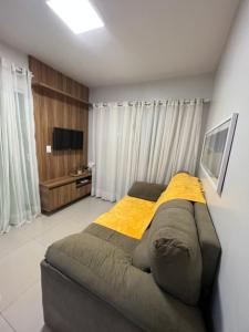 a bedroom with a large bed with a yellow blanket at Casa em Condomínio agradável com fundo pro rio in Barreirinhas