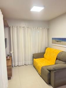 um quarto com uma cama e um cobertor amarelo em Casa em Condomínio agradável com fundo pro rio em Barreirinhas