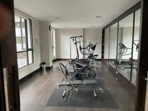 un gimnasio con 2 bicicletas estáticas y espejos en Apartamento Quito tenis, en Quito