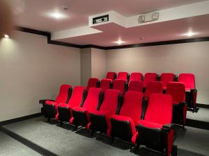 una sala de cine vacía con sillas rojas. en Apartamento Quito tenis, en Quito
