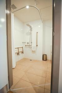 a bathroom with a shower and a tiled floor at Lava Hotel in Apia