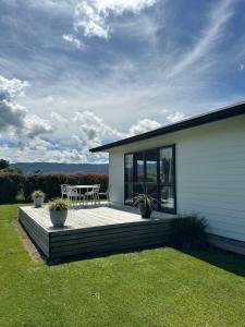 a house with a deck with a table at A Place in the Paddock in Matamata