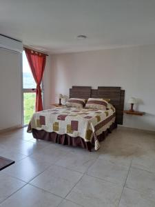 een slaapkamer met een bed en een groot raam bij Huayruro in San Salvador de Jujuy