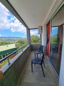 Un balcón con 2 sillas y vistas. en Huayruro en San Salvador de Jujuy