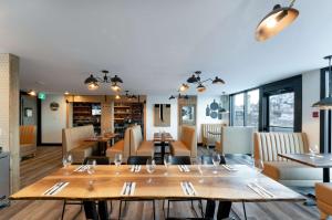 restauracja z drewnianymi stołami i krzesłami oraz jadalnią w obiekcie Prestige Kamloops Hotel w mieście Kamloops