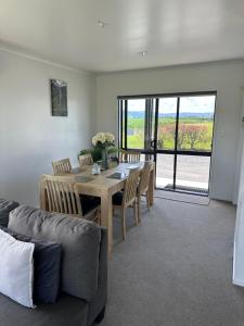 a dining room with a table and chairs and a couch at A Place in the Paddock in Matamata