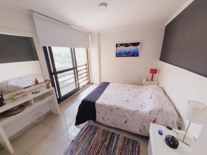 Dormitorio pequeño con cama y TV en Departamento céntrico Etoile 3 Confort totalmente equipado Piscina y asadores en Villa Carlos Paz