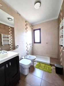 y baño con aseo, bañera y lavamanos. en Departamento céntrico Etoile 3 Confort totalmente equipado Piscina y asadores en Villa Carlos Paz