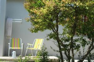 two chairs and a tree in front of a building at Departamento interno zona centro in Viedma