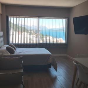 1 dormitorio con cama y ventana grande en Postal del Nahuel en San Carlos de Bariloche