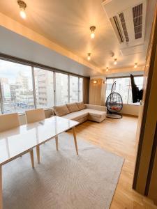 高松市にあるHotel Yuzukiのソファとテーブルのあるリビングルーム