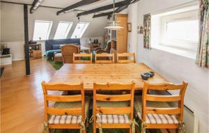 comedor y sala de estar con mesa de madera y sillas en Beautiful Apartment In Sams With House Sea View, en Ballen