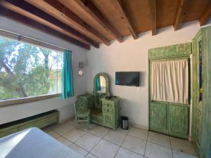 um quarto com uma cama, um espelho e uma janela em Casa Árbol Hotel em San Miguel de Allende