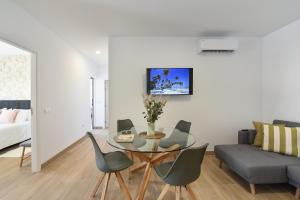 - un salon avec une table, des chaises et un canapé dans l'établissement Apartamento Starlight La Aldea II, à San Nicolás