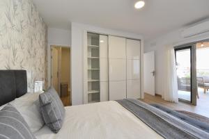a bedroom with a large bed and a sliding glass door at Apartamento Starlight La Aldea II in La Aldea de San Nicolas +13 photos