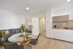 una sala de estar blanca con mesa de cristal y sillas en Apartamento Starlight La Aldea II, en San Nicolás