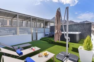an apartment with a rooftop patio with an umbrella at Apartamento Starlight La Aldea II in La Aldea de San Nicolas