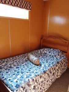 een bed in een kleine kamer met een raam bij Cabaña la raspa in Castro