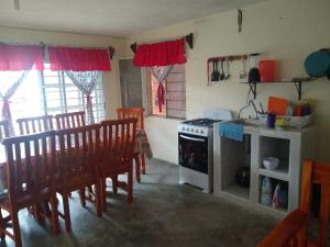 a kitchen with a stove and a table and chairs at CASA EL DELFÍN ROSADO in Tecolutla