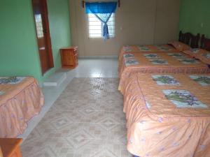 a room with three beds and a window at CASA EL DELFÍN ROSADO in Tecolutla