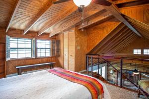 a bedroom with a large bed in a room with wooden walls at Lakeside Escape in Lakehills