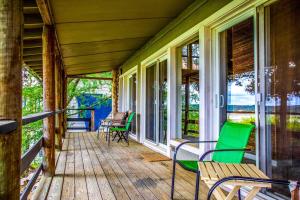 a porch with chairs and tables and windows at Lakeside Escape in Lakehills