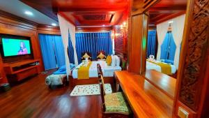 ein Schlafzimmer mit zwei Betten und einem Fernseher darin in der Unterkunft Try Palace Resort Sihanoukville in Sihanoukville