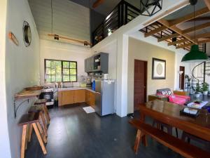 a kitchen with a dining table and a refrigerator at Laguna Loft Camiguin in Mambajao